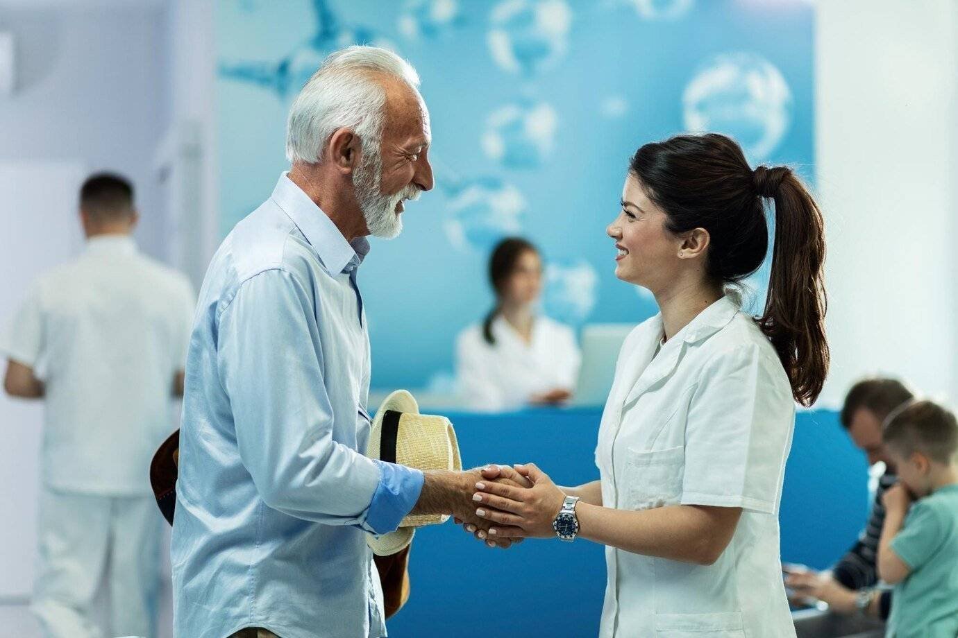 happy senior man handshaking with female doctor while talking lobby clinic_637285 460